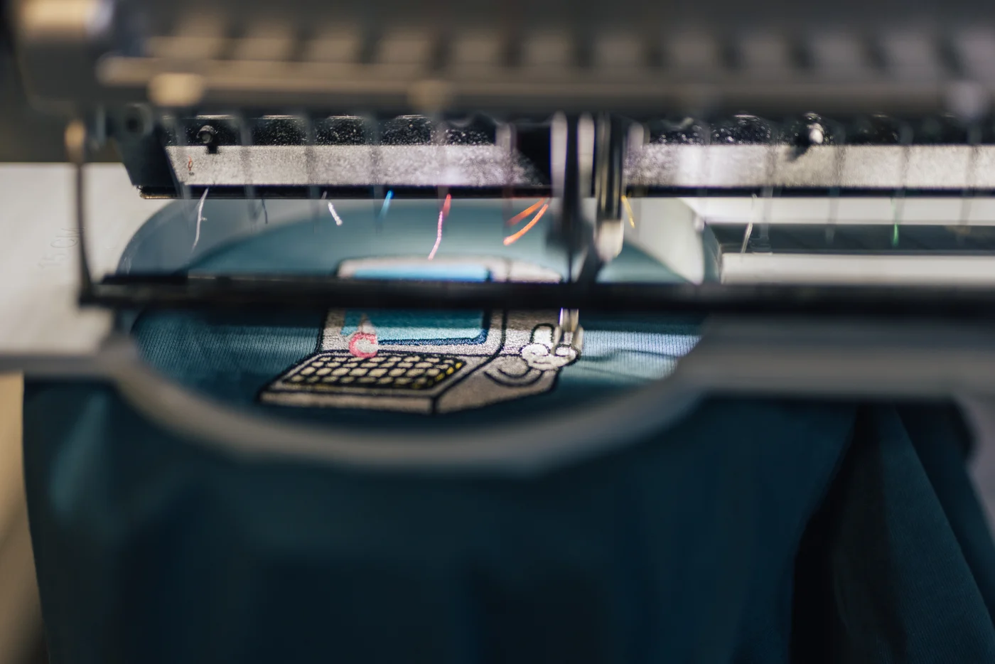 An embroidery machine stitching a detailed garment design